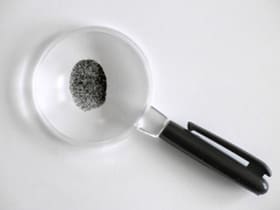 A magnifying glass with a fingerprint in it.